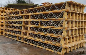 Stacks of Posi-Joists outside a warehouse on a wet day