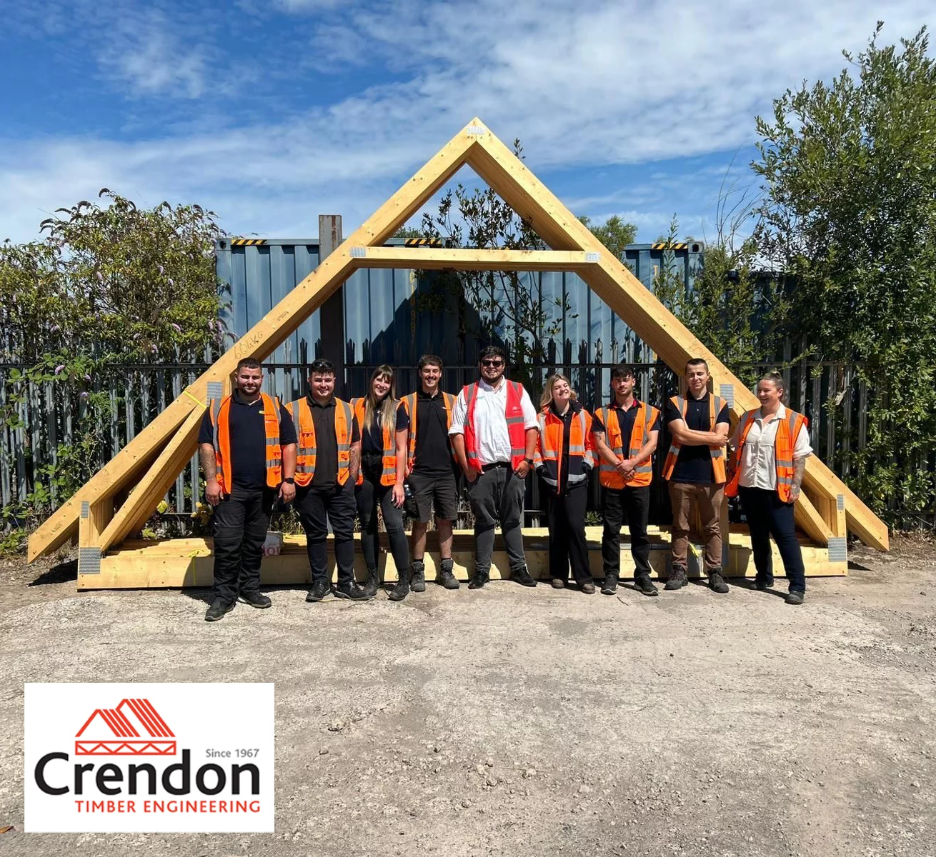 A group of people standing for a photo in front of a Crendon Timber Engineering Roof Truss