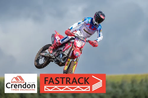 Man on motorcross bike riding through dirt track