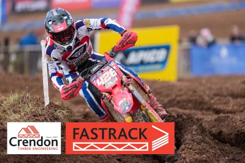 Man on motorcross bike riding through dirt track