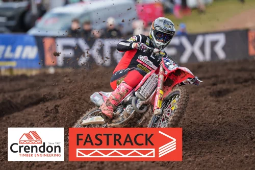 Man on motorcross bike riding through dirt track