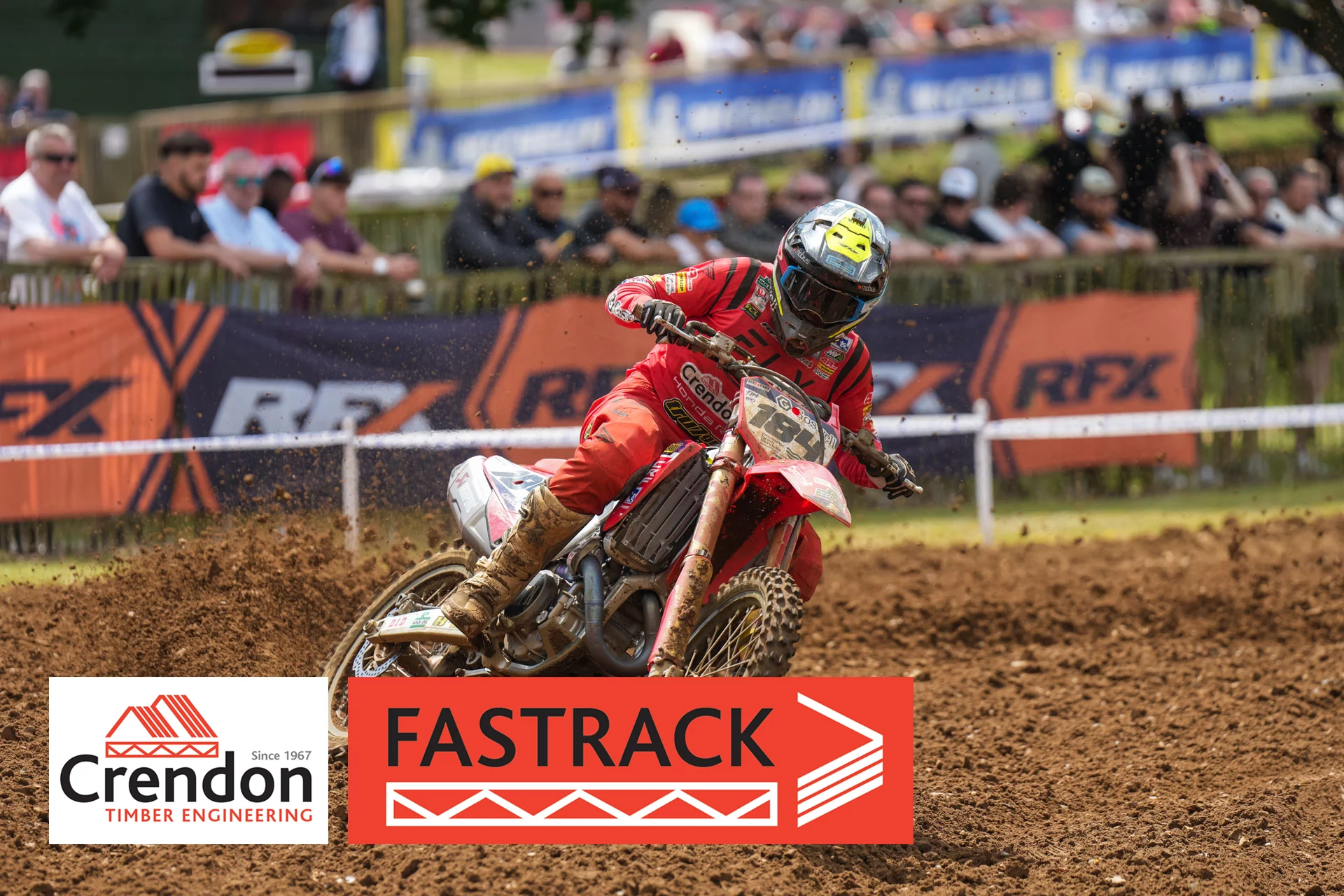 A motocross rider on a dirt track from a side angle. 