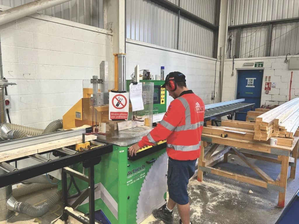 Man using saw to cut timber