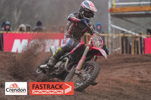 Biker on a red bike on a dirt track.