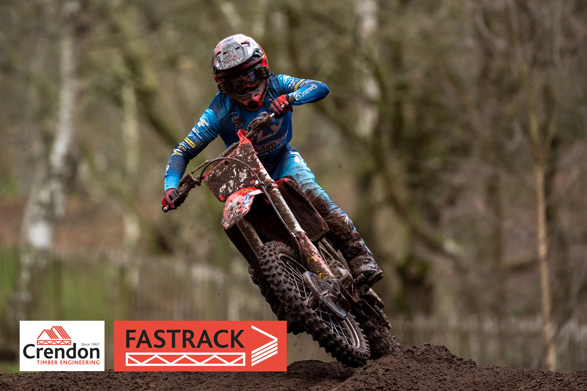 Biker in blue on a bike on a dirt track. 