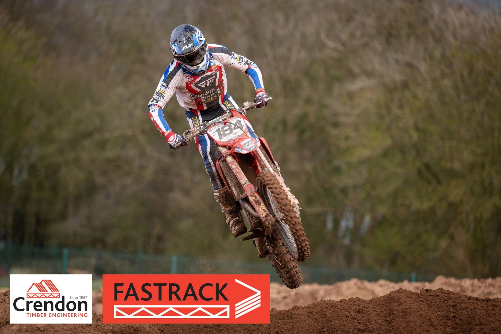 A motocross rider jumping off the dirt track.