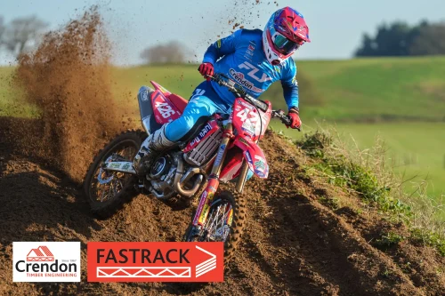 A biker riding through the dirt tarck.
