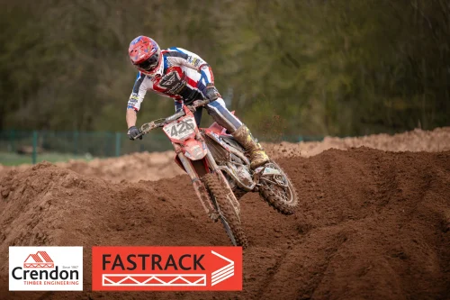 A motocross biker riding on a dirt track.