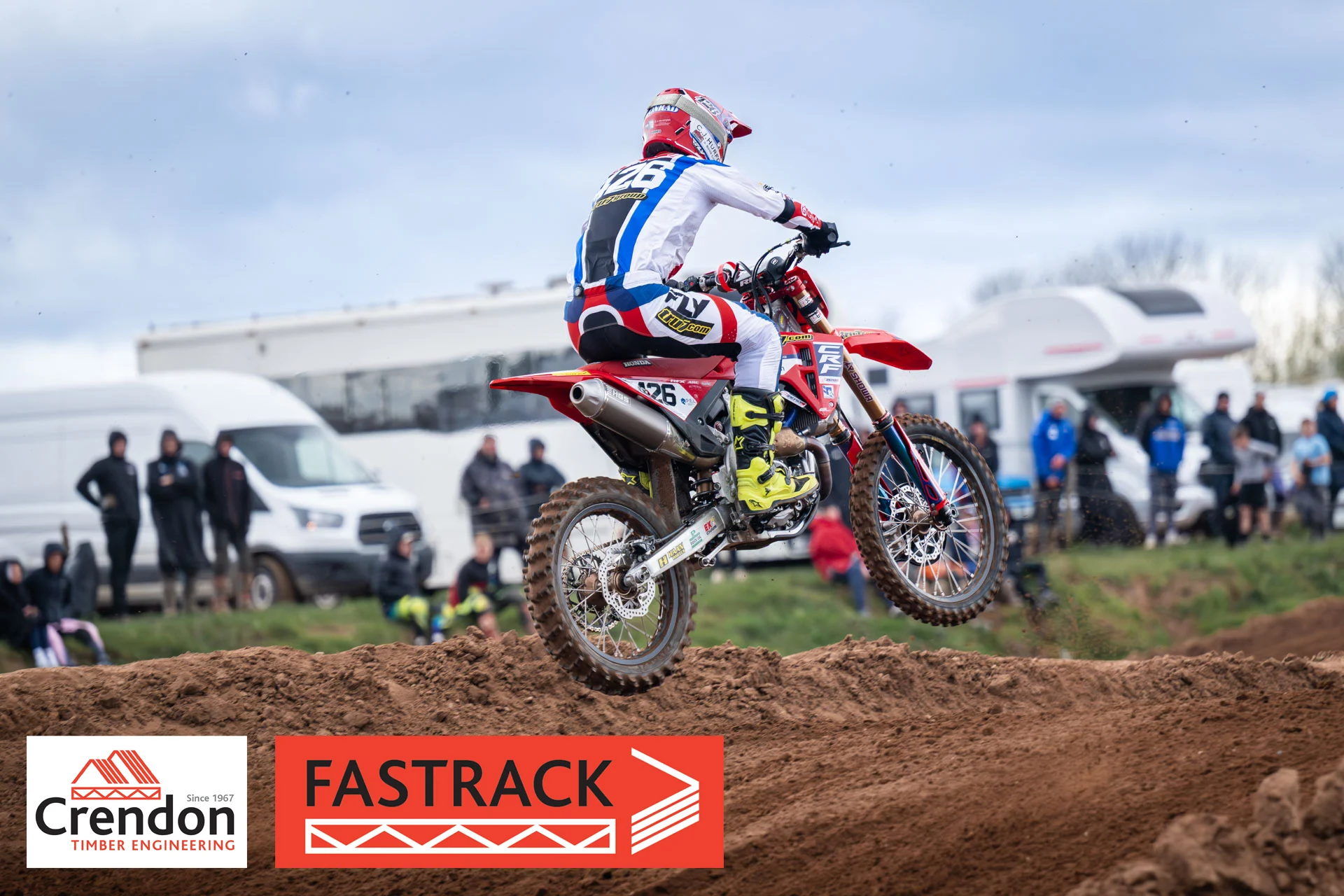 A motocross rider up in the air a little. 