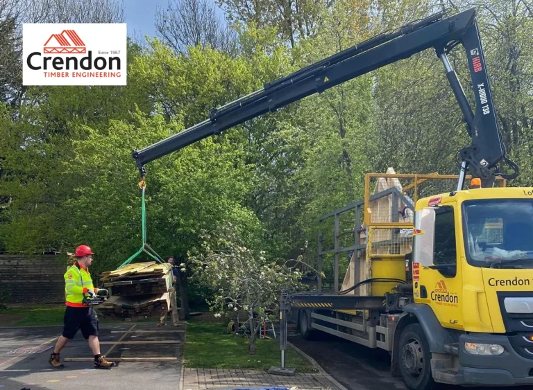 2026-Baltonborough-School-Donation-cropped-1-768x563 Crendon Crane lifting wooden materials down to the ground in a car park surrounded by trees.