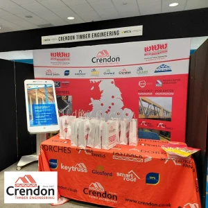 Red Crendon stand at a show with white bags on the table