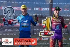 Two motorcross bikers holding podium signs