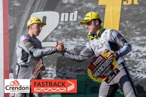 2 motorcross riders shaking hands on the podium