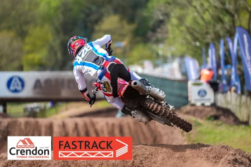 A biker slightly off the ground whilst at a left angle off the dirt.