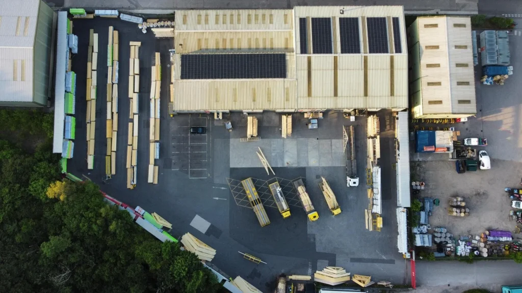 Birds eye view of a loading bay with multiple trucks and trailers with racking holding materials