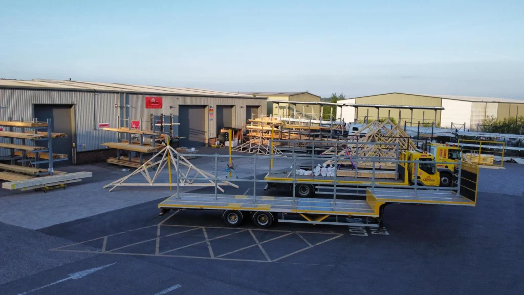 Loading bay with multiple trucks and trailers with racking holding materials