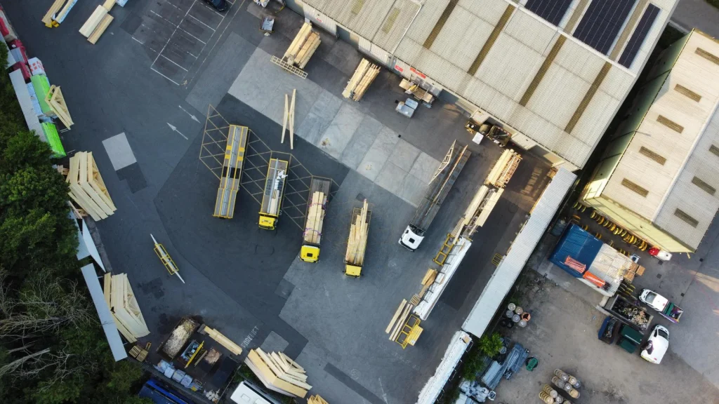 Birds eye view of the loading bay with multiple trucks and trailers and racking holding materials