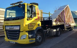 Yellow lorry holding roof trusses