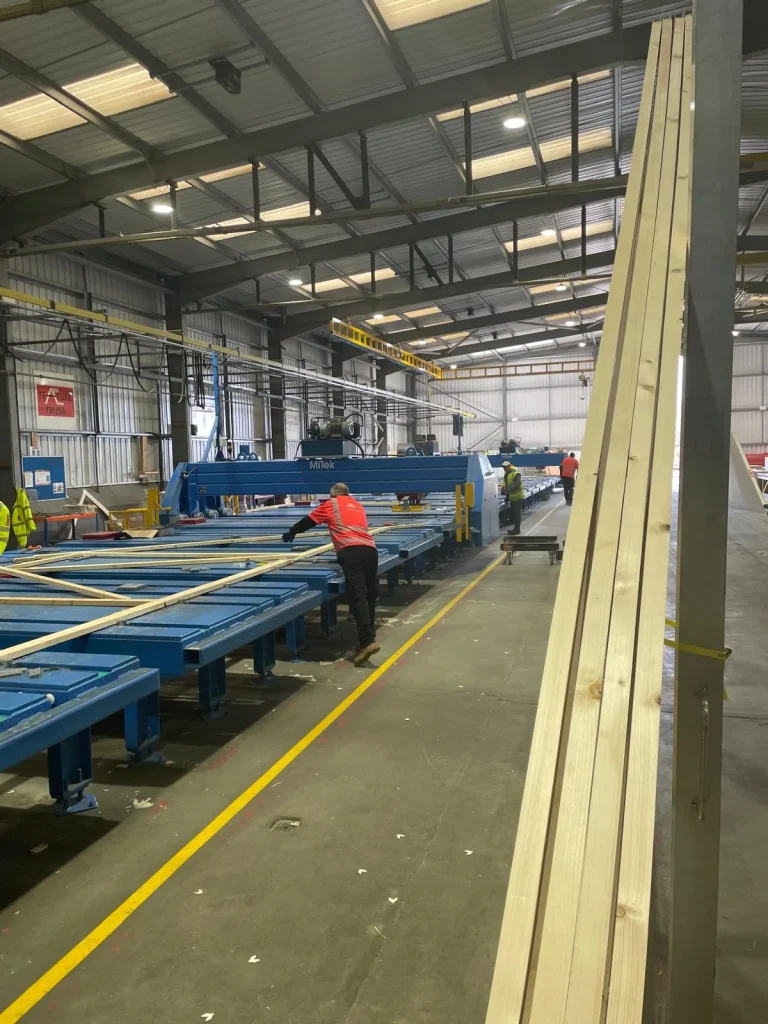 Workers along work benches and machinery