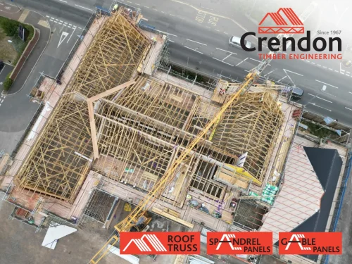 Birdseye view of roof of tall building, roof consists of spandrel and gable panels with a crane over the top