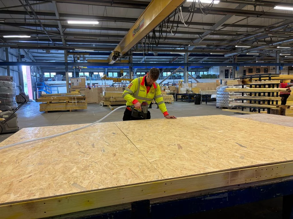 Worker attaching materials together using a nail gun
