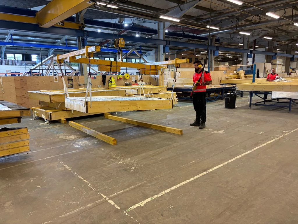 Worker moving products with lifting machinery in a warehouse