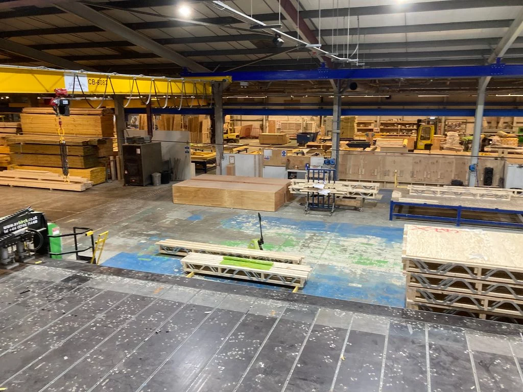 Warehouse with stacks of Posi-Joists, stacks of materials and machinery