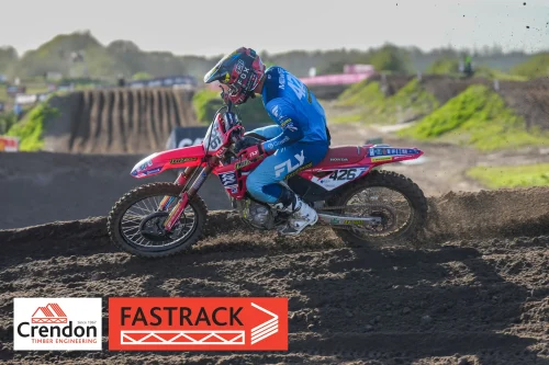 a motocross rider going round the corner on a dirt bike. 