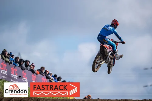 A motocross bike rider in the air doing a jump.