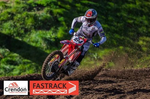 A motocross bike rider spewing up dirt on the track.