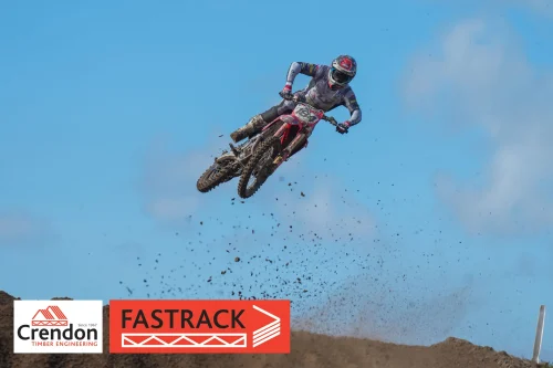 A motocross rider doing a jump off the dirt track.