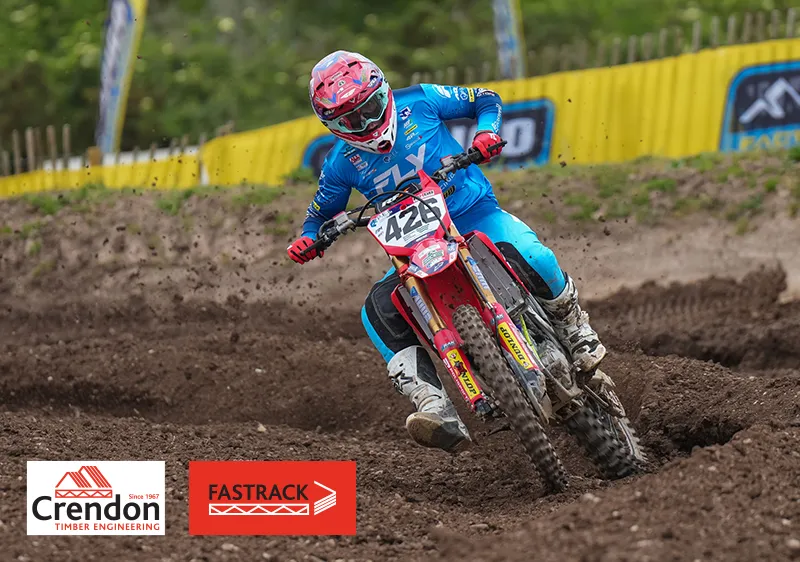 Man in blue outfit on a bike on a dirt track