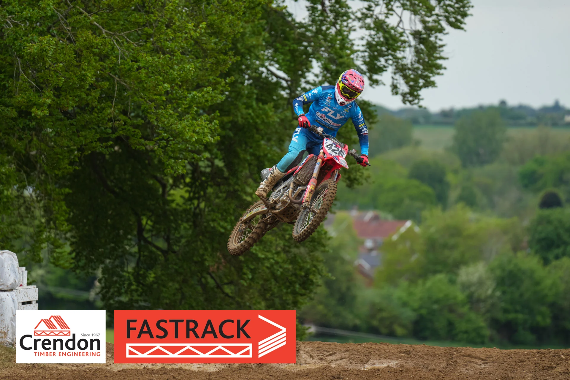 A motocross rider doing a jump and is up in the air.